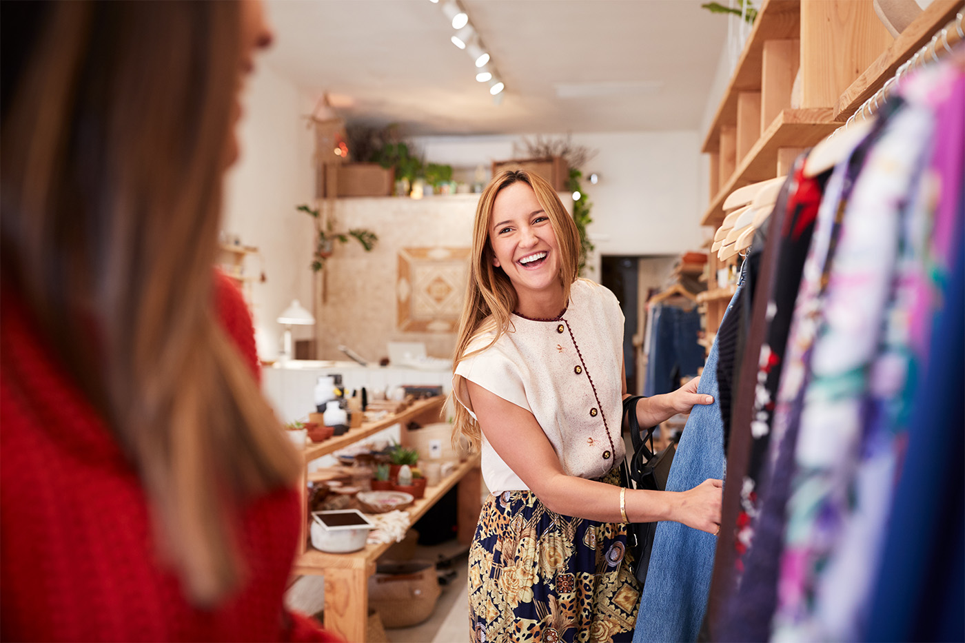 two happy women shopping in a retail clothing store
