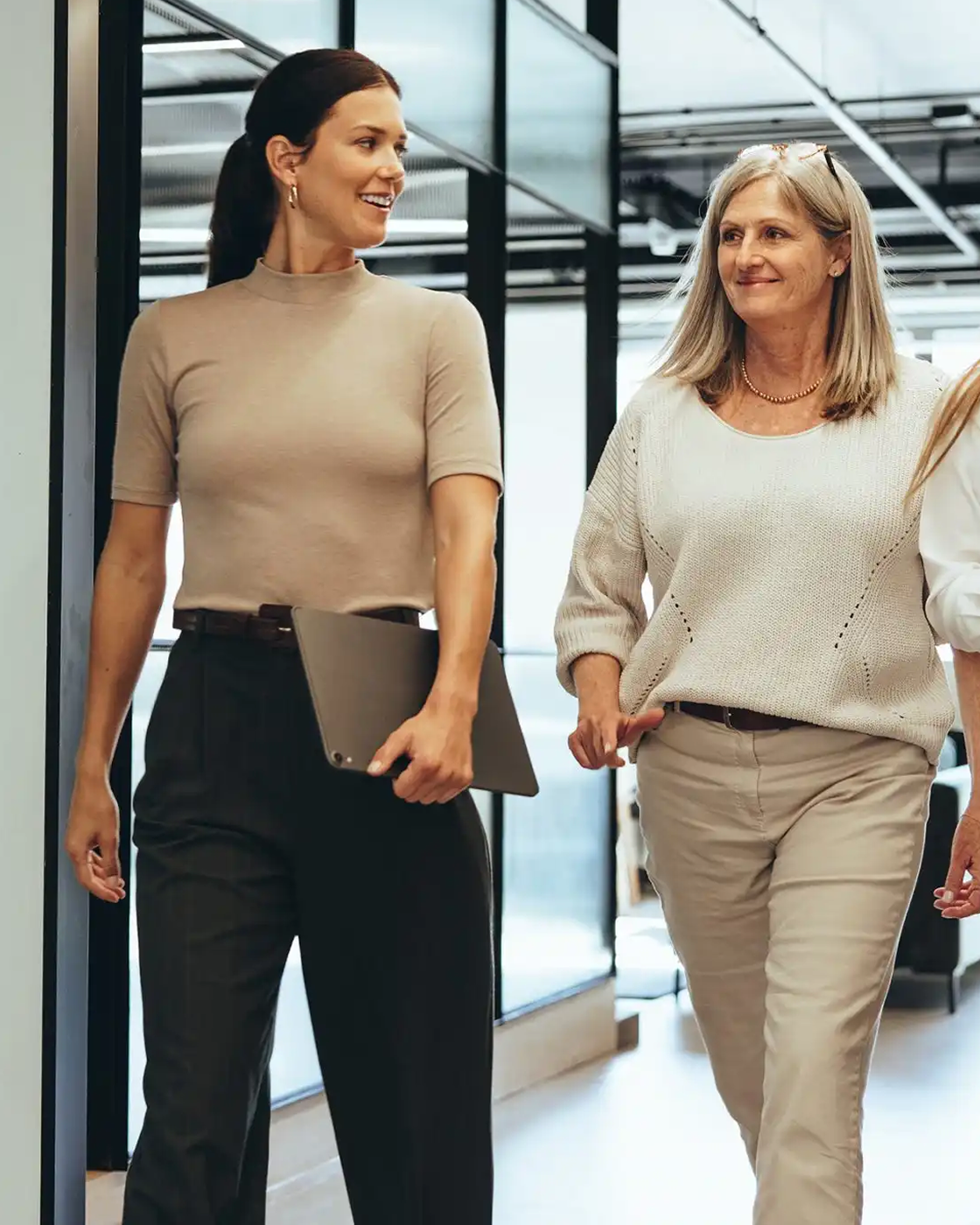 Image of two women walking in an office setting