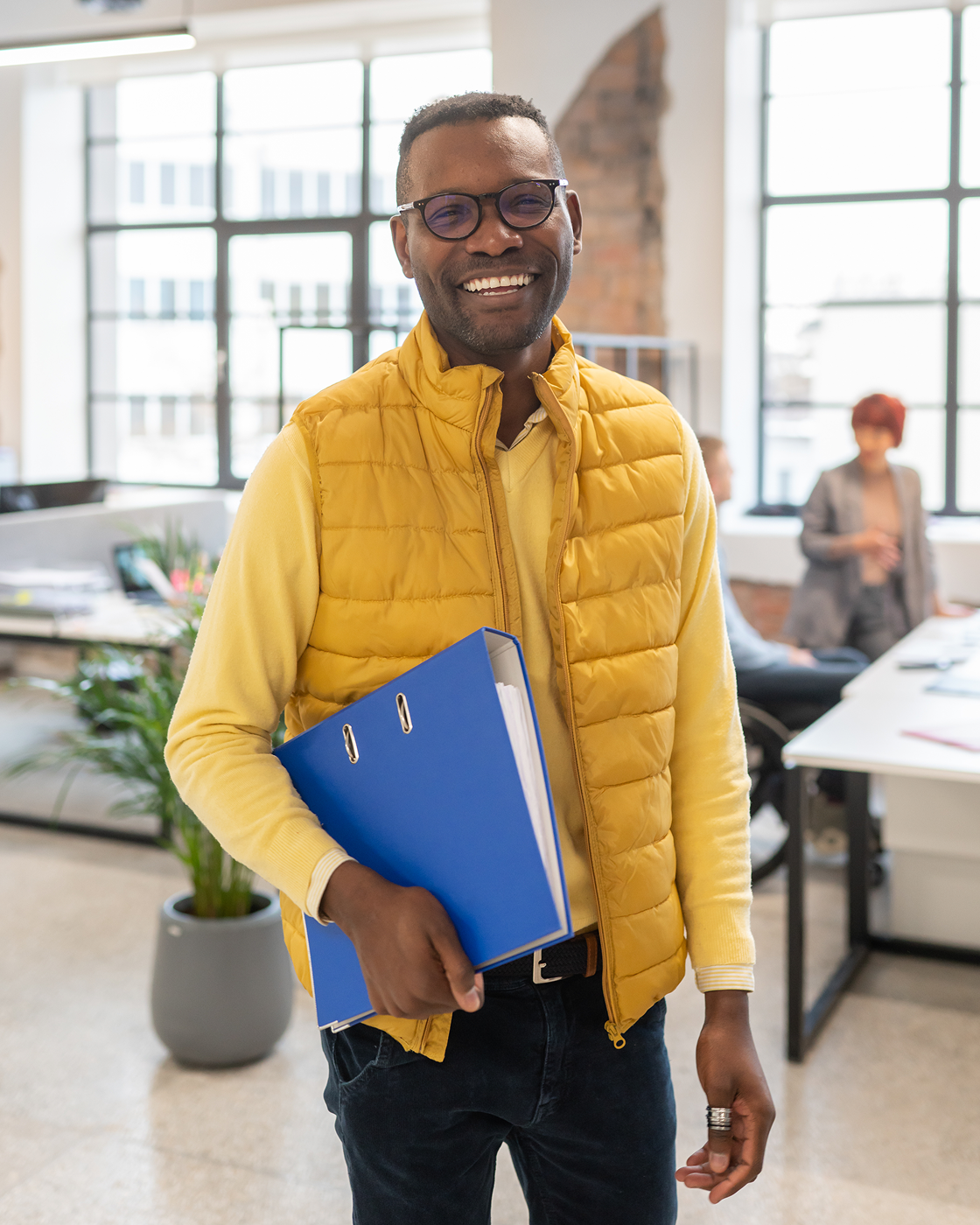 Image of a man smiling while holding a binder