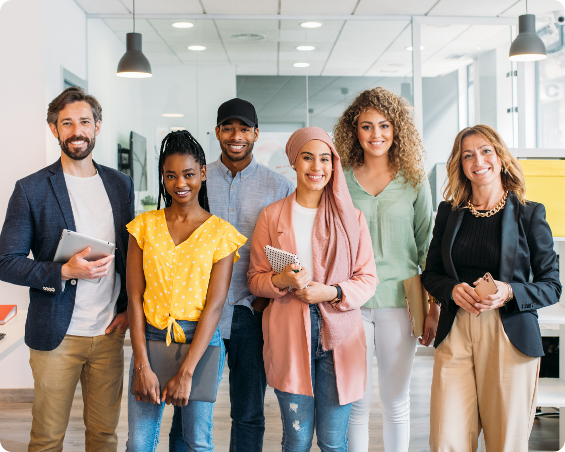 Image of six people in an office standing in a row smiling to camera