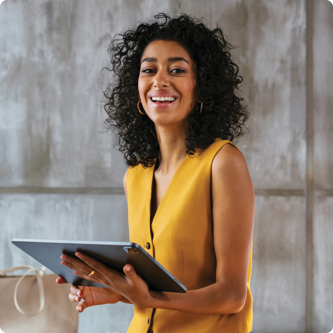 Image of a woman holding a tablet and smiling to camera