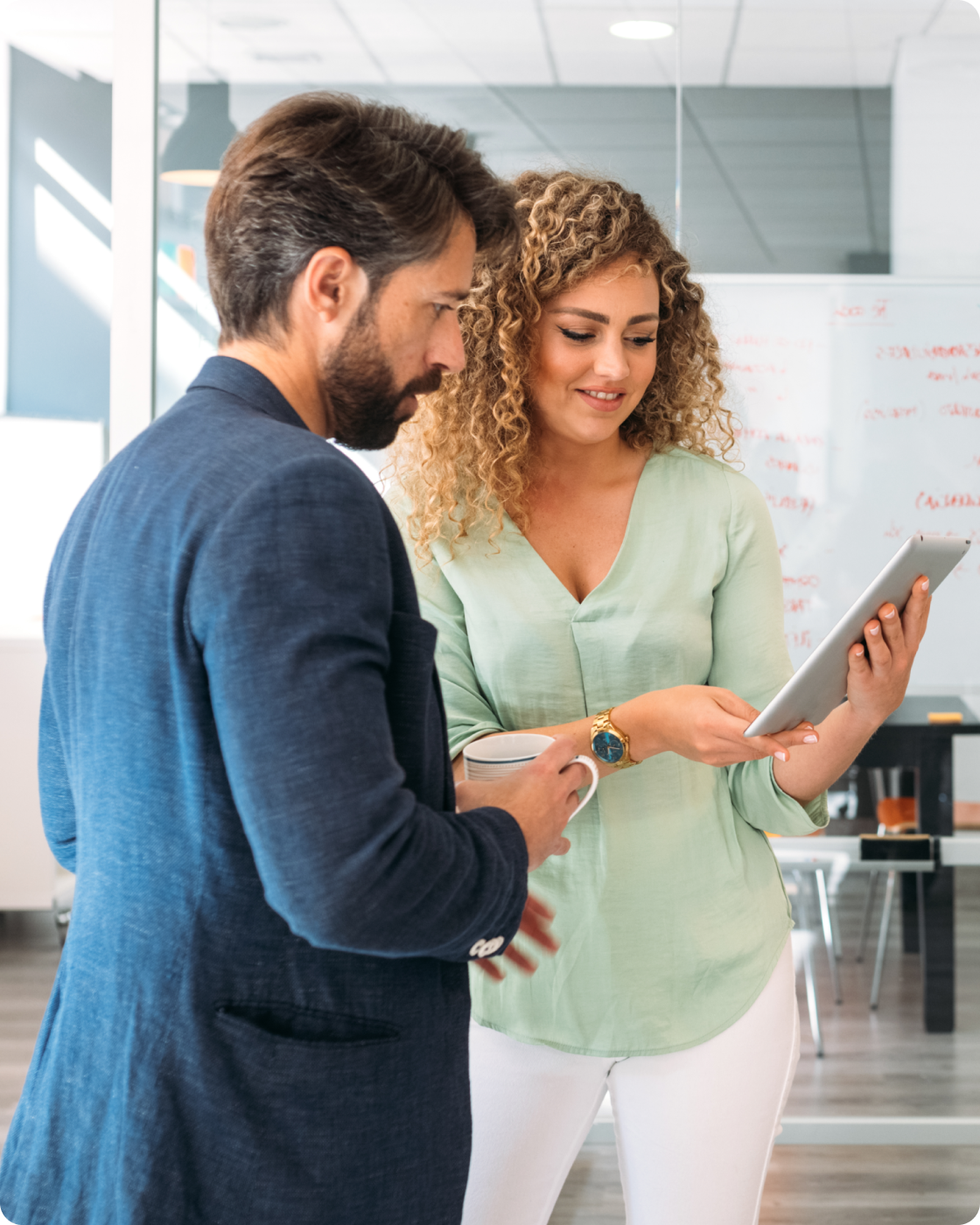 Image of coworkers standing in an office looking at tablet
